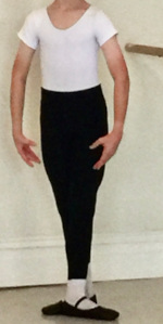 Dancer wearing white leotard, black tights and black ballet shoes